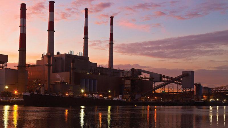 Photo of power plant by the water at sunset